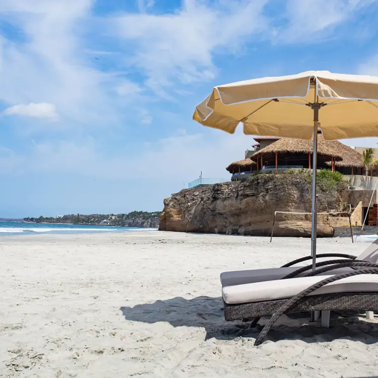Lounge chairs and sun umbrella on the beach at Armony Marival, Puerto Vallarta