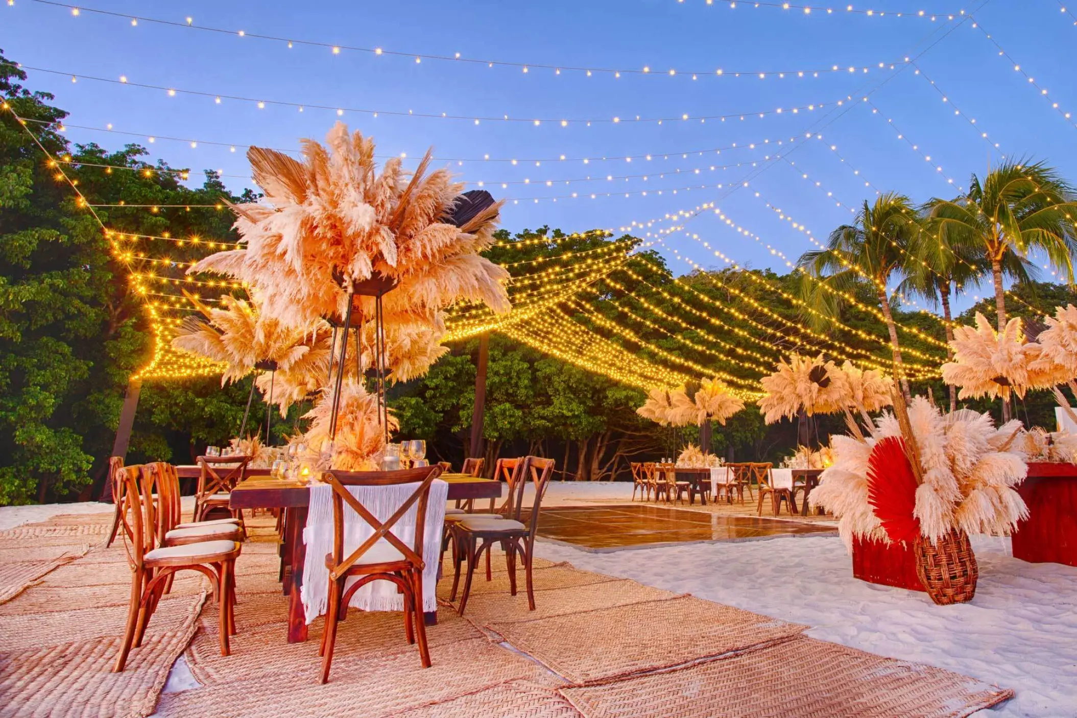 Beach wedding reception with pampas grass decor and string lights at Armony Marival, Puerto Vallarta