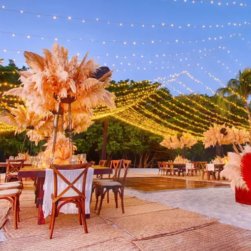 Beach wedding reception with pampas grass decor and string lights at Armony Marival, Puerto Vallarta