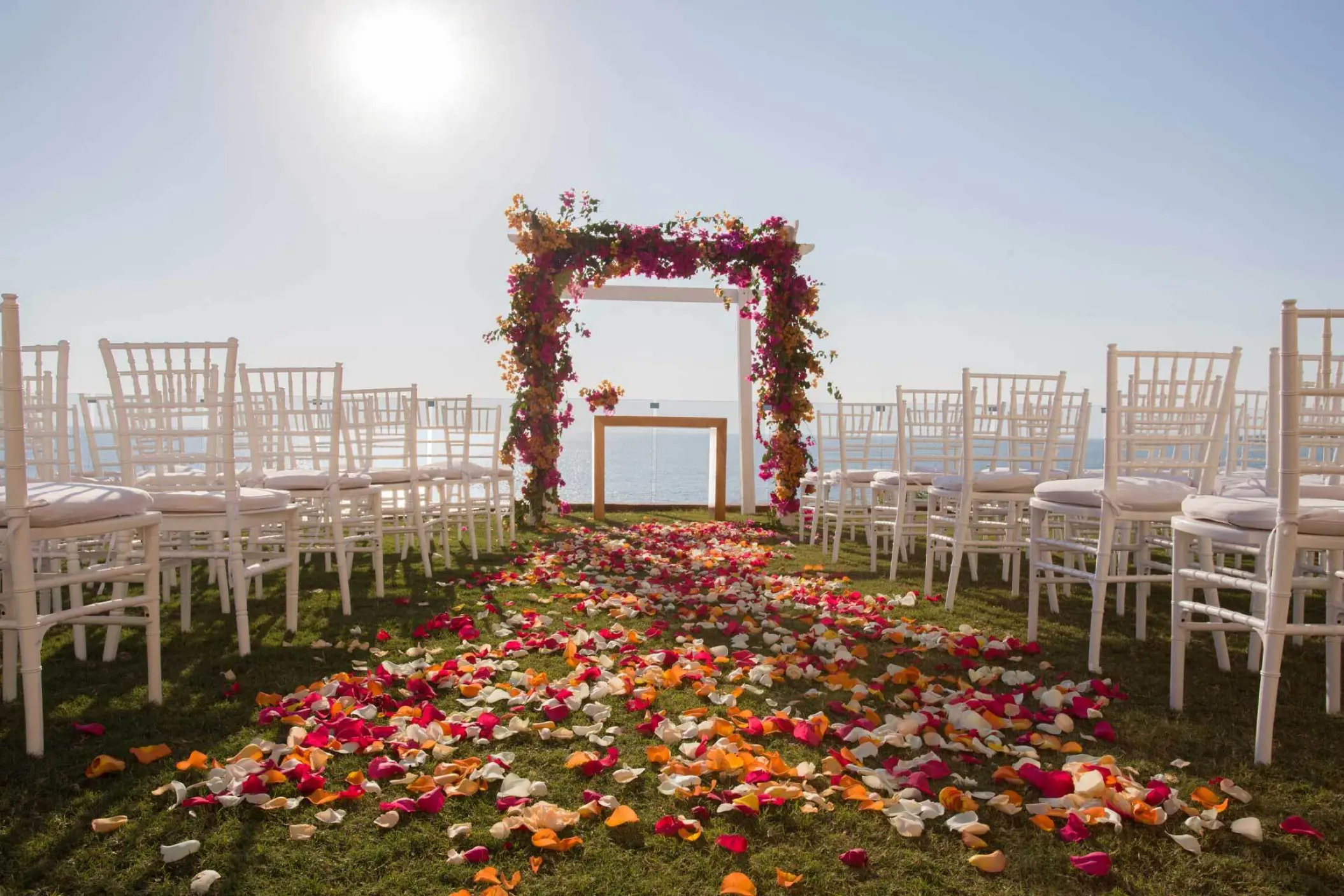 Garden wedding ceremony setup with flower petals and white chairs at Marival Armony, Puerto Vallarta