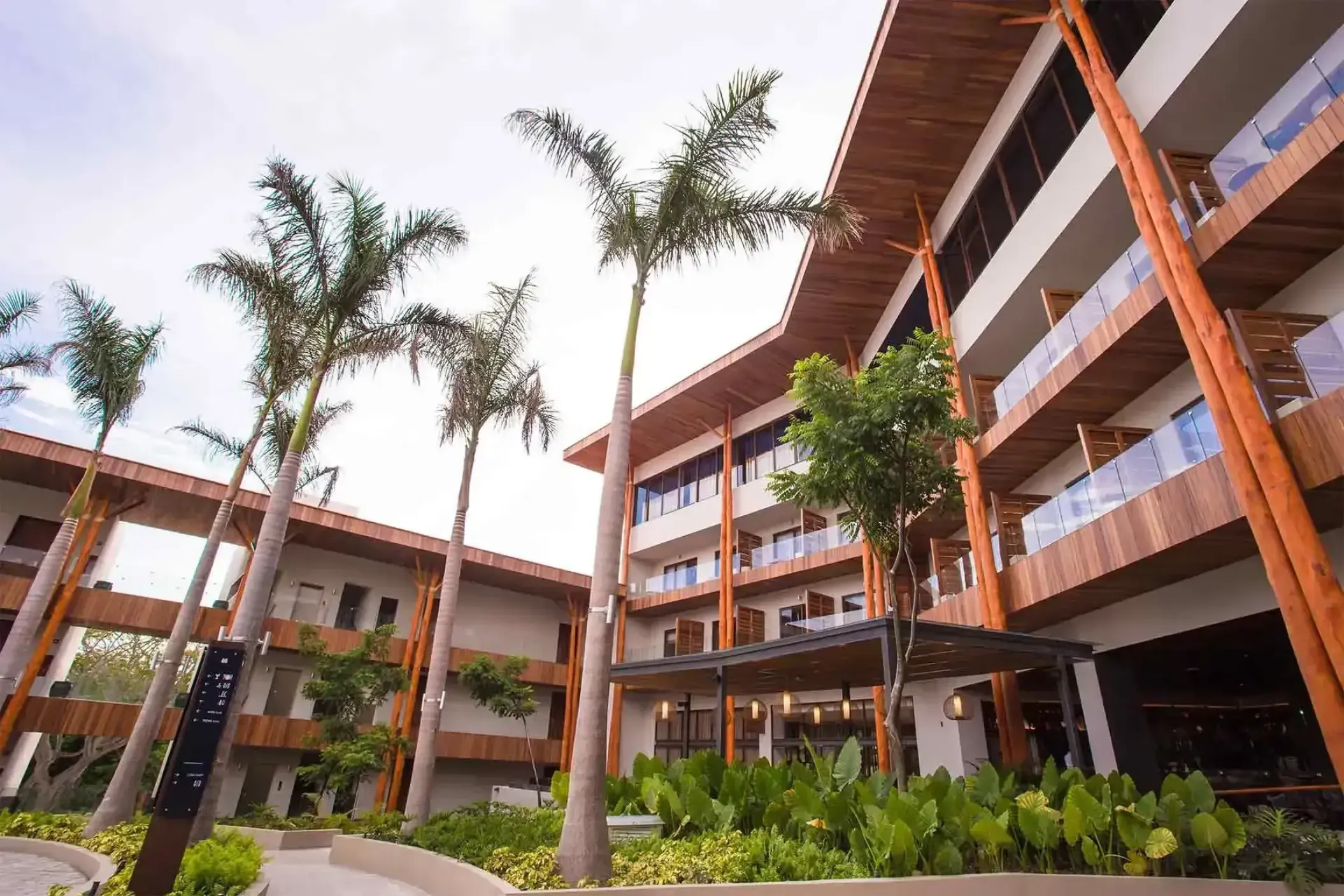 Modern hotel facade and palm trees at Armony Marival Resort, Puerto Vallarta