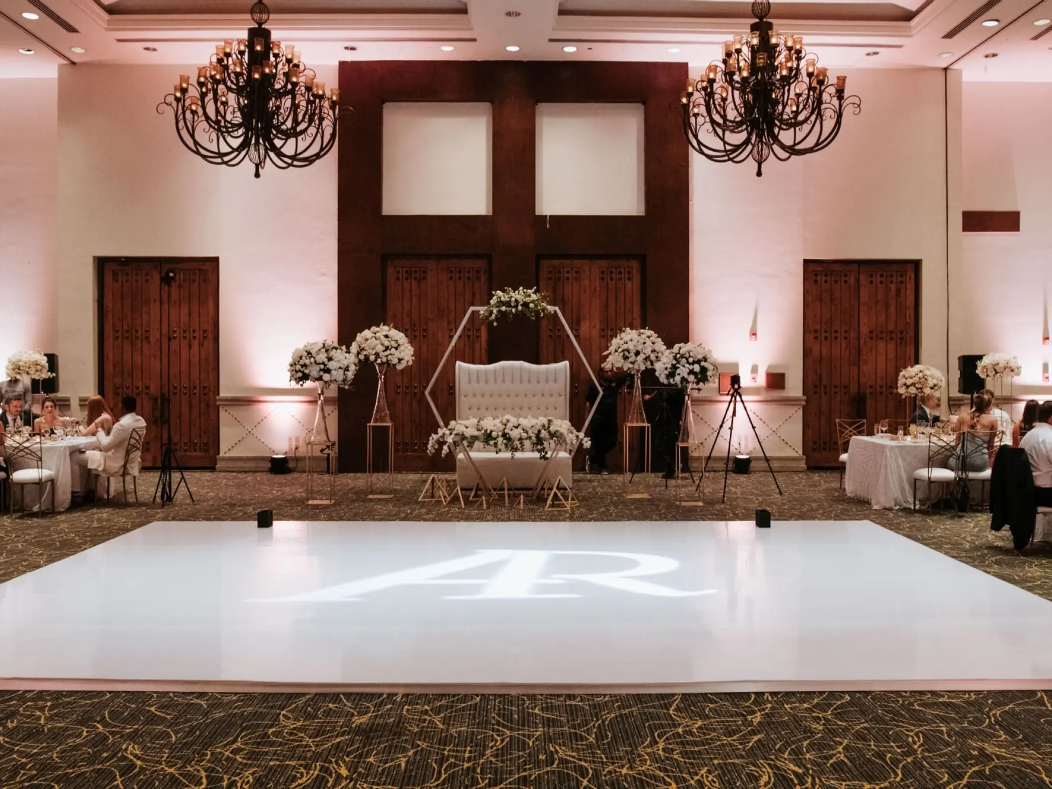 Indoor ballroom wedding reception with a monogrammed dance floor at Marquis Los Cabos, Cabo San Lucas