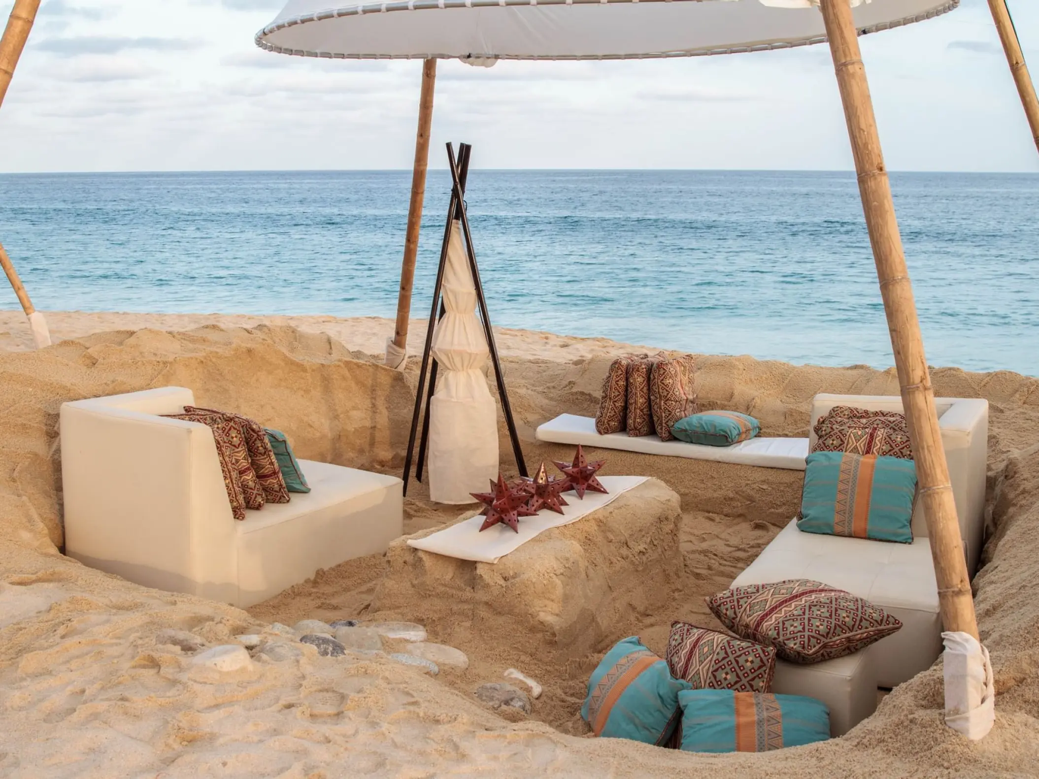 Sunken sand lounge with sofas and pillows for a beach reception at Marquis Los Cabos, Cabo San Lucas