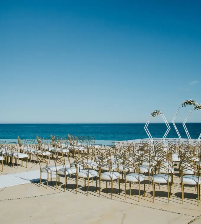 Oceanfront wedding ceremony setup with geometric arches at Marquis Los Cabos, Cabo San Lucas