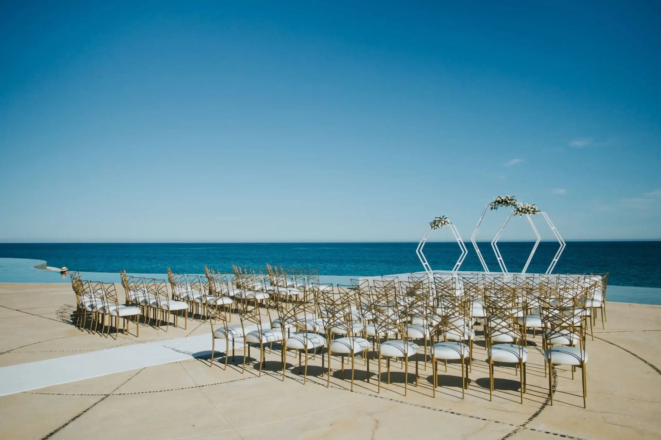Oceanfront wedding ceremony setup with geometric arches at Marquis Los Cabos, Cabo San Lucas
