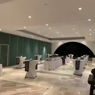 Indoor wedding reception setup with cocktail tables and buffet at Marquis Los Cabos, Cabo San Lucas