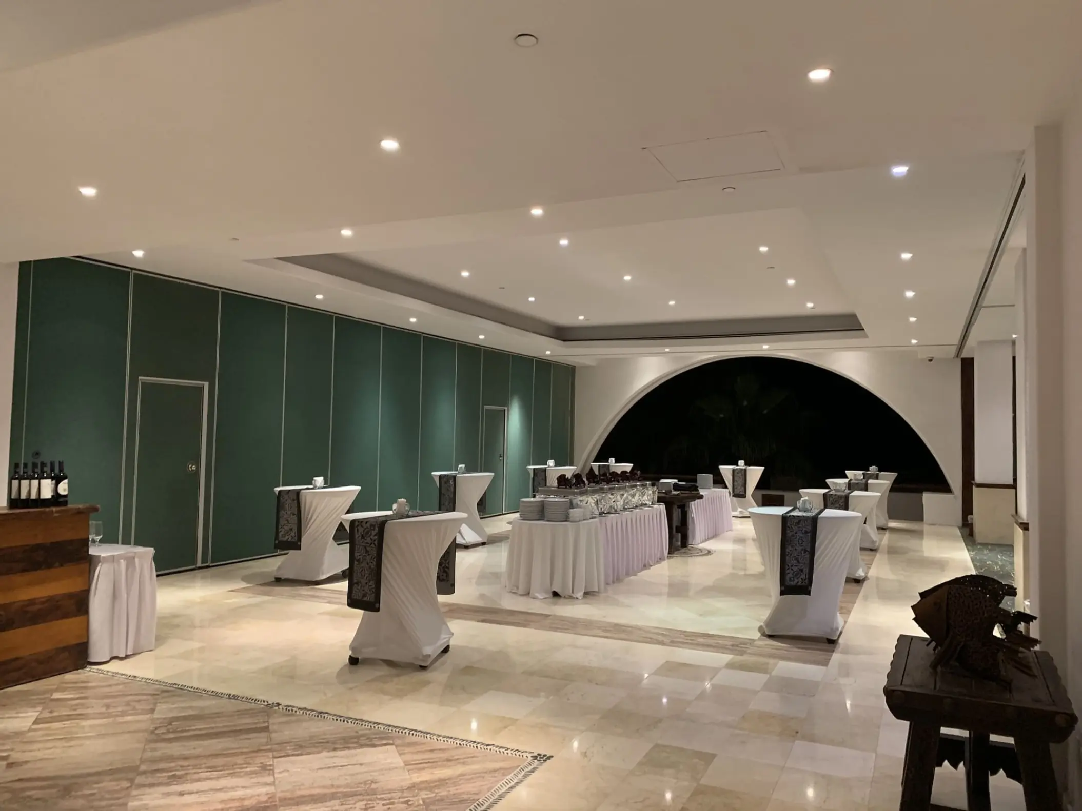 Indoor wedding reception setup with cocktail tables and buffet at Marquis Los Cabos, Cabo San Lucas