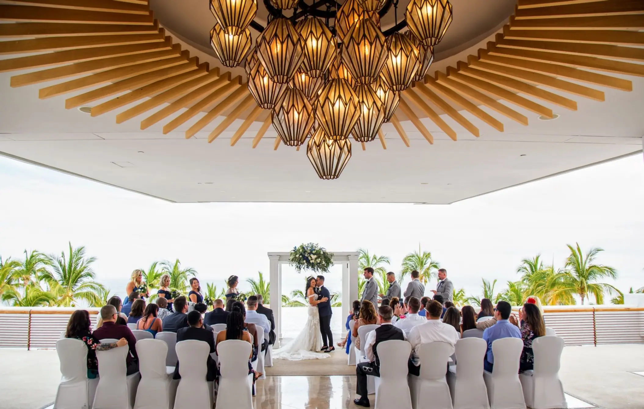 Wedding ceremony under a geometric chandelier at Marquis Los Cabos, Cabo San Lucas