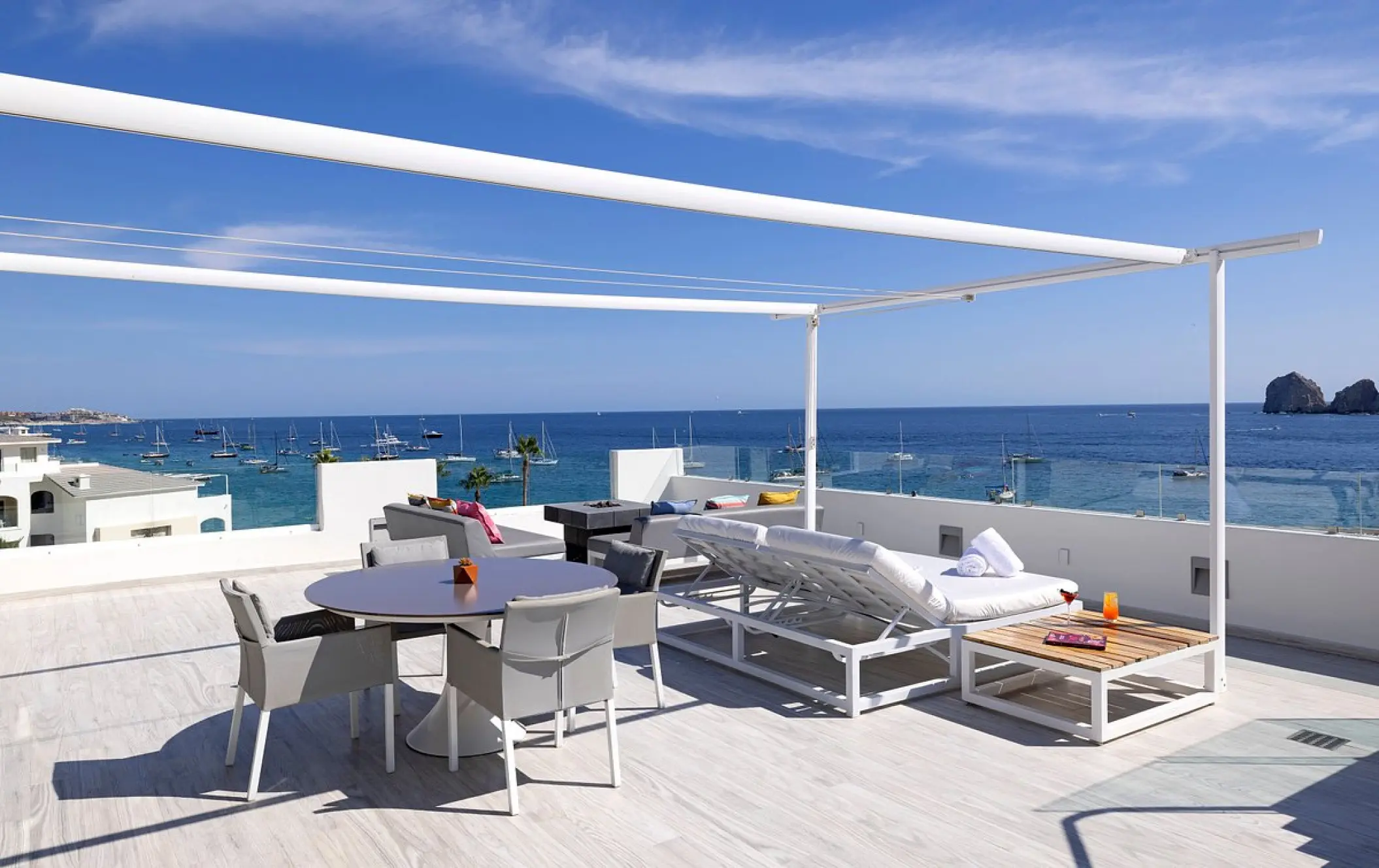 Rooftop terrace with lounge seating and ocean views at ME Cabo, Cabo San Lucas