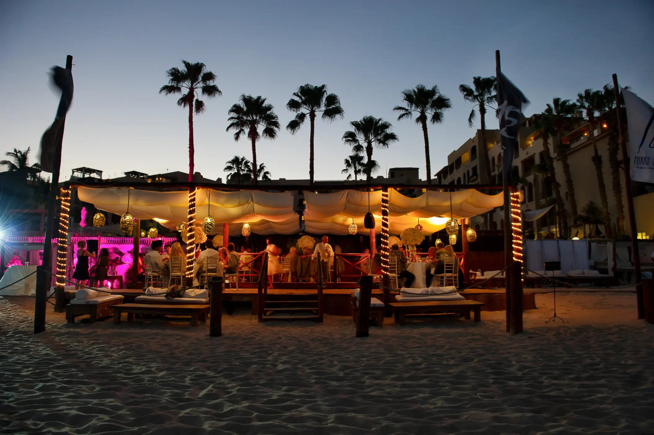 Evening wedding reception under a lighted canopy at ME Cabo, Cabo San Lucas