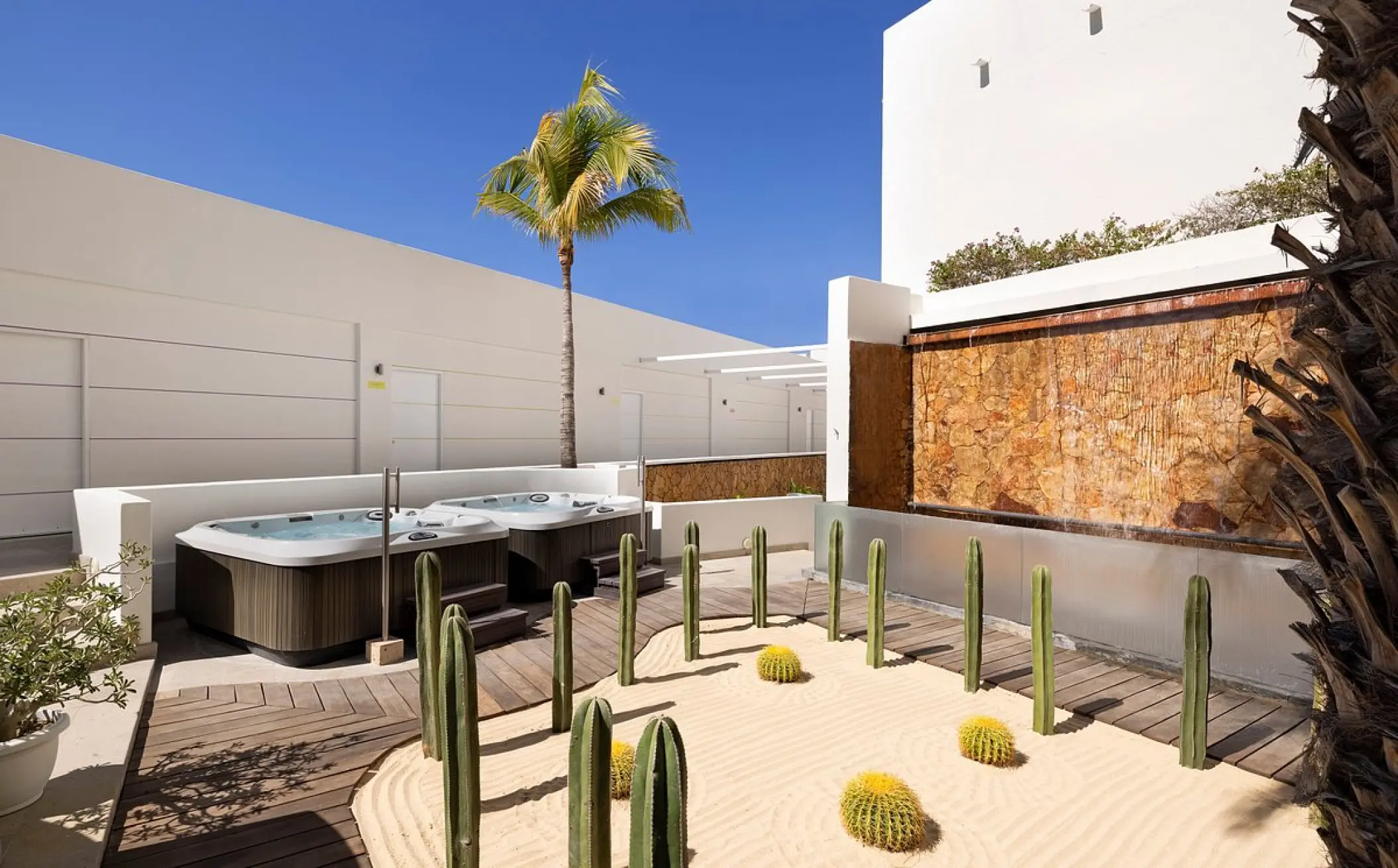 Outdoor spa terrace with hot tubs and a cactus garden at ME Cabo, Cabo San Lucas