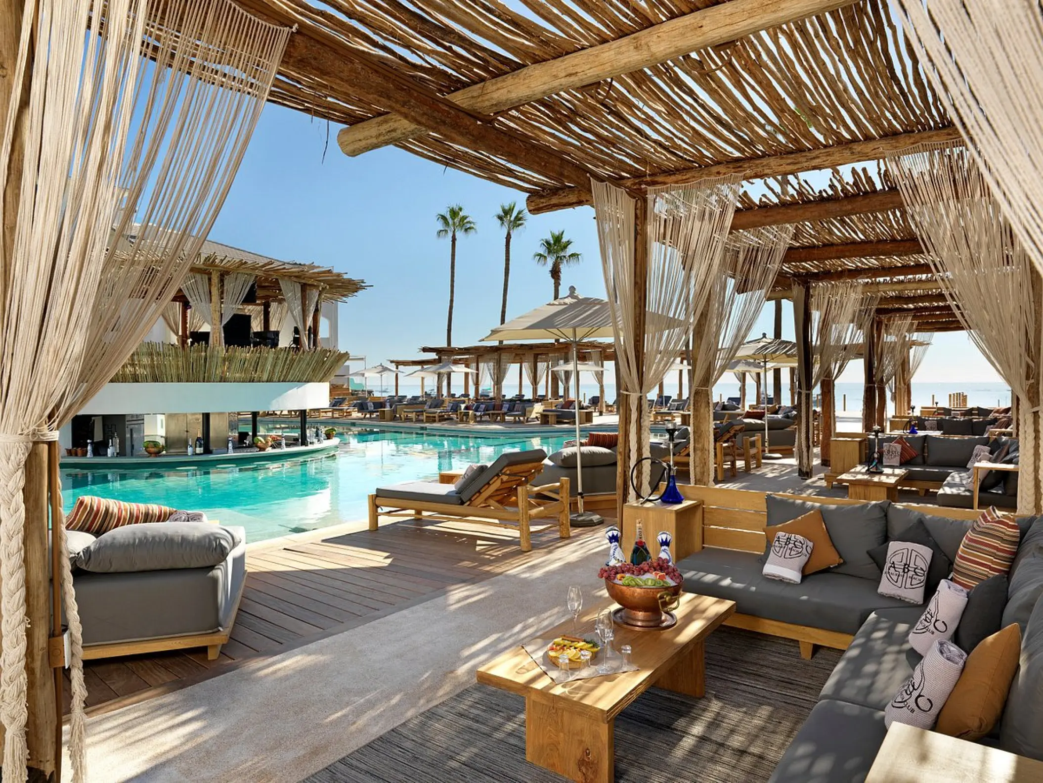 VIP lounge with shaded seating and pool view at ME Cabo, Cabo San Lucas
