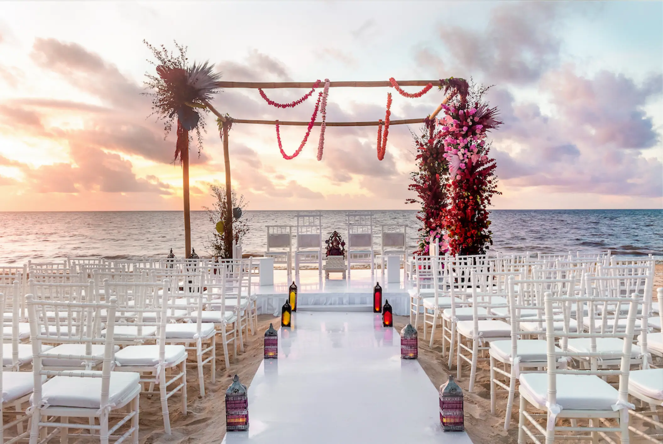 Beachfront wedding ceremony with a floral wooden gazebo at Moon Palace Cancun