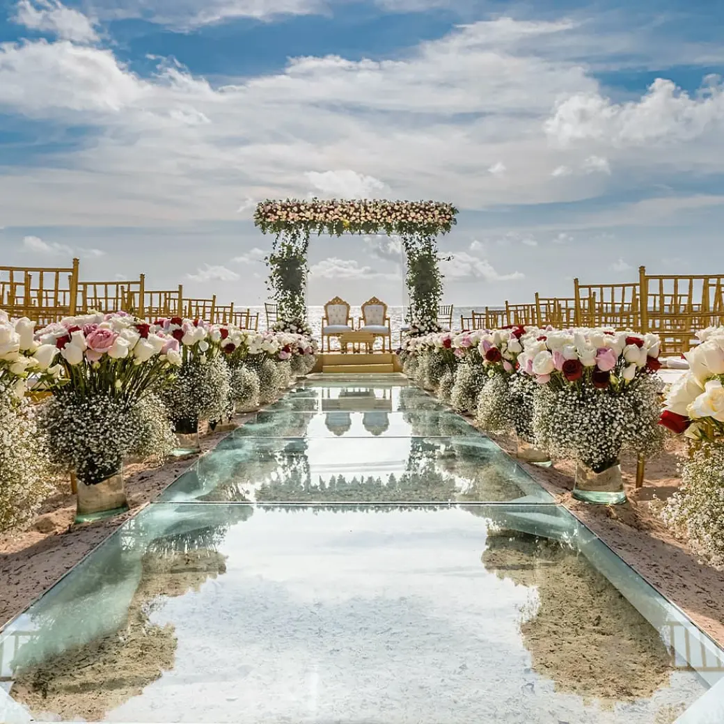 Glass aisle and floral arrangements for a beach ceremony at Moon Palace Cancun