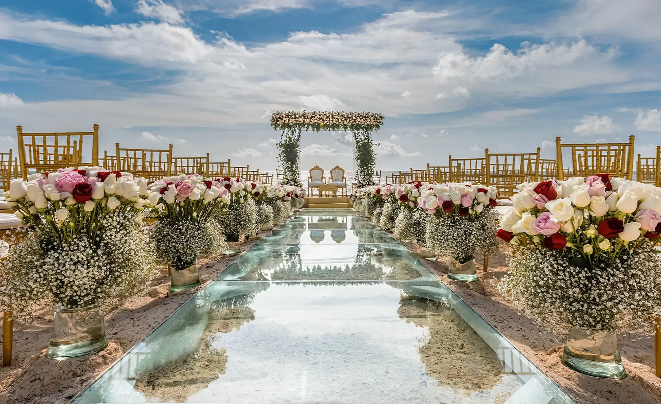 Glass aisle and floral arrangements for a beach ceremony at Moon Palace Cancun