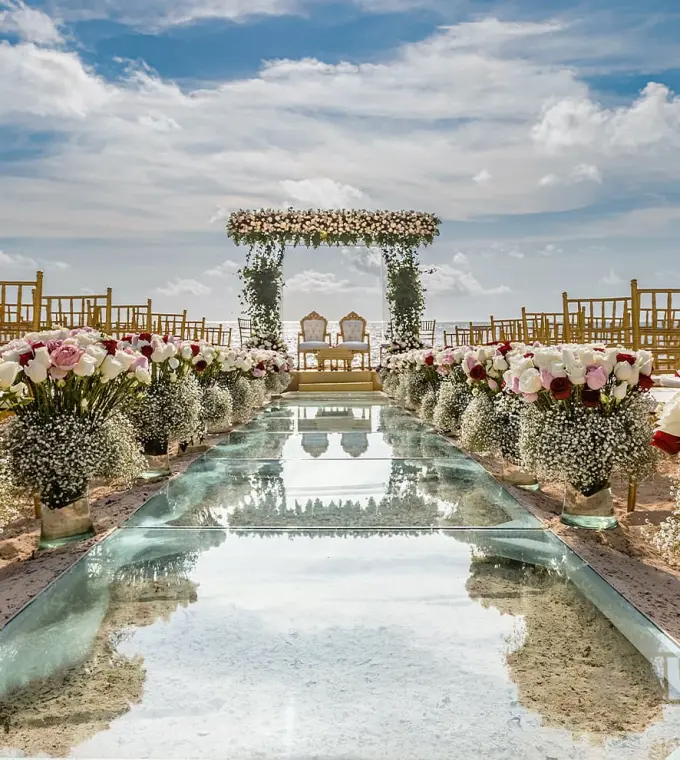 Glass aisle and floral arrangements for a beach ceremony at Moon Palace Cancun