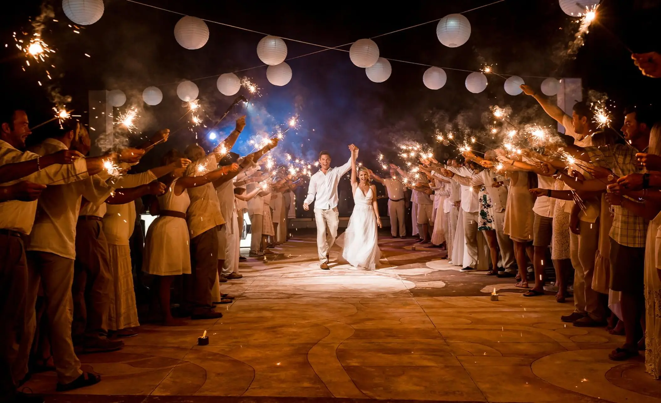 Bride and groom walking through a sparkler exit at Moon Palace Cancun
