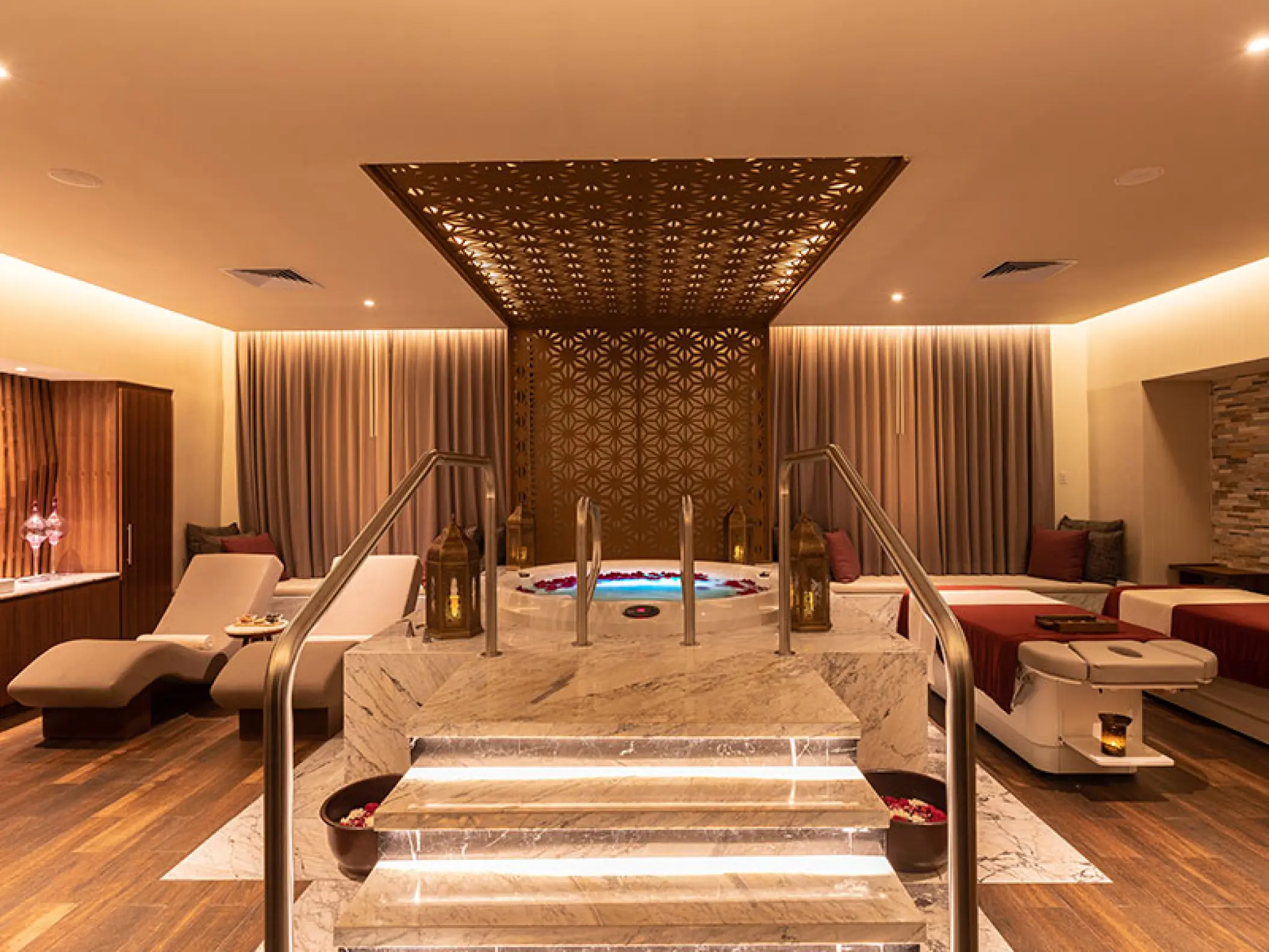 Indoor spa jacuzzi and lounge area with marble steps at Moon Palace Cancun
