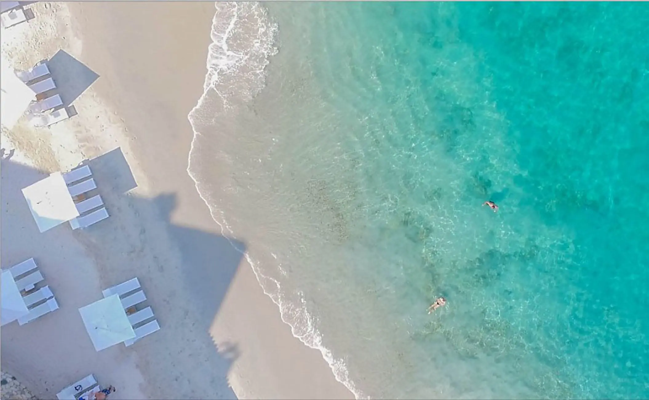 Aerial view of white umbrellas and turquoise water at Hotel Mousai, Puerto Vallarta