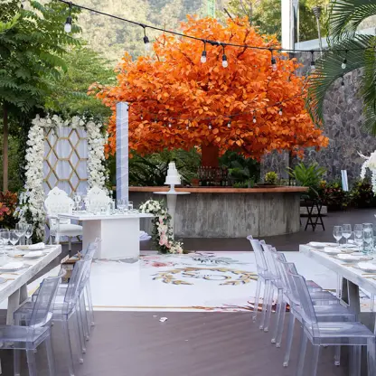 Wedding reception at Garza Blanca Puerto Vallarta with ghost chairs and an orange tree focal point