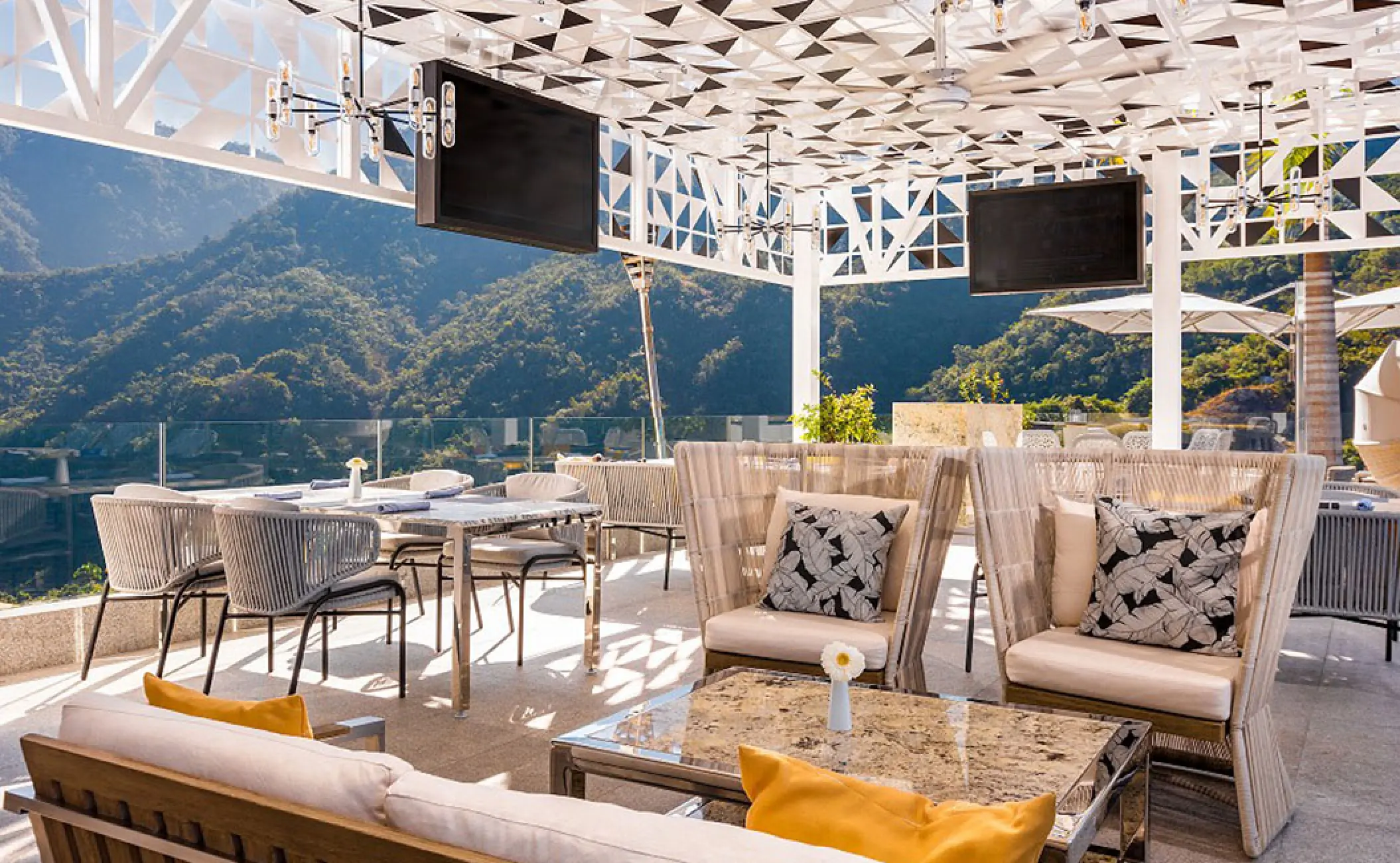 Rooftop terrace lounge and dining area with mountain views at Hotel Mousai, Puerto Vallarta