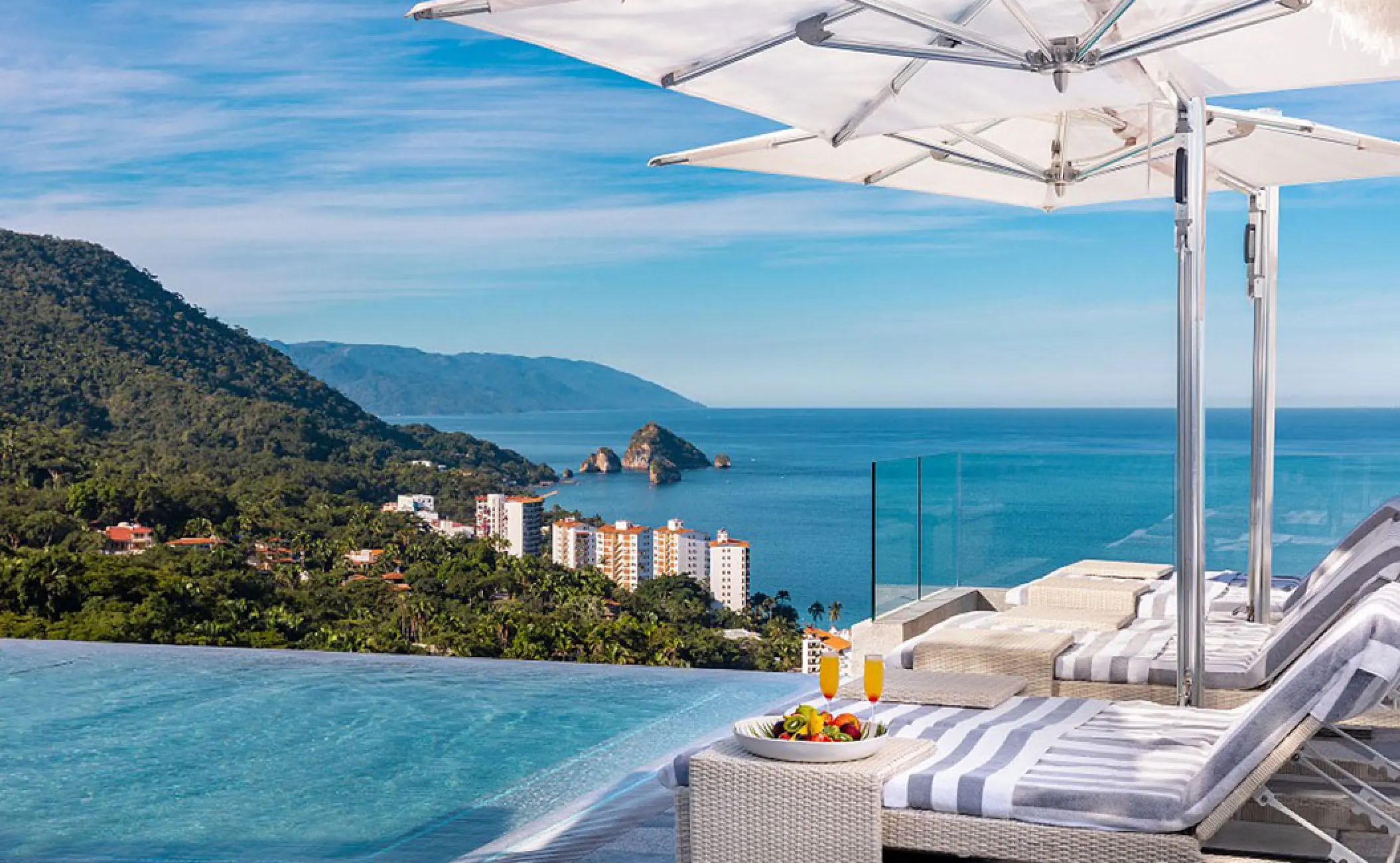 Rooftop infinity pool with lounge chairs at Hotel Mousai, Puerto Vallarta