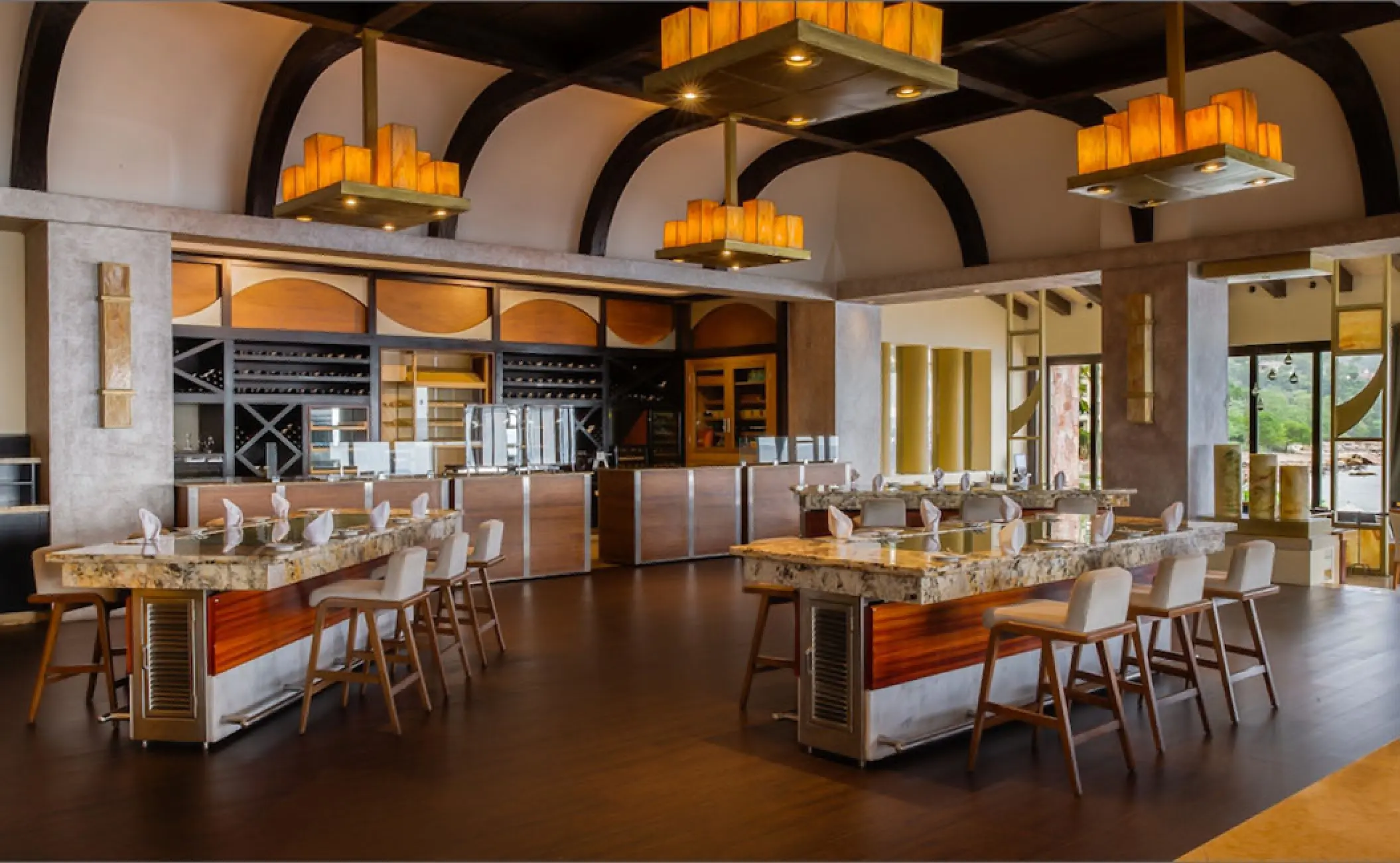 Modern restaurant dining room with stone tables and high-top seating at Garza Blanca Puerto Vallarta