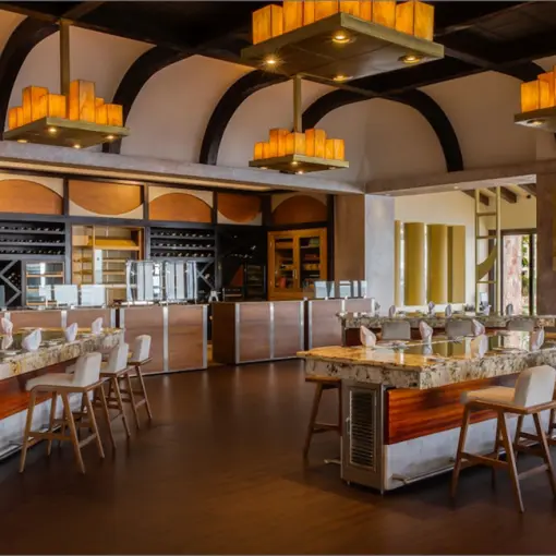 Modern restaurant dining room with stone tables and high-top seating at Garza Blanca Puerto Vallarta