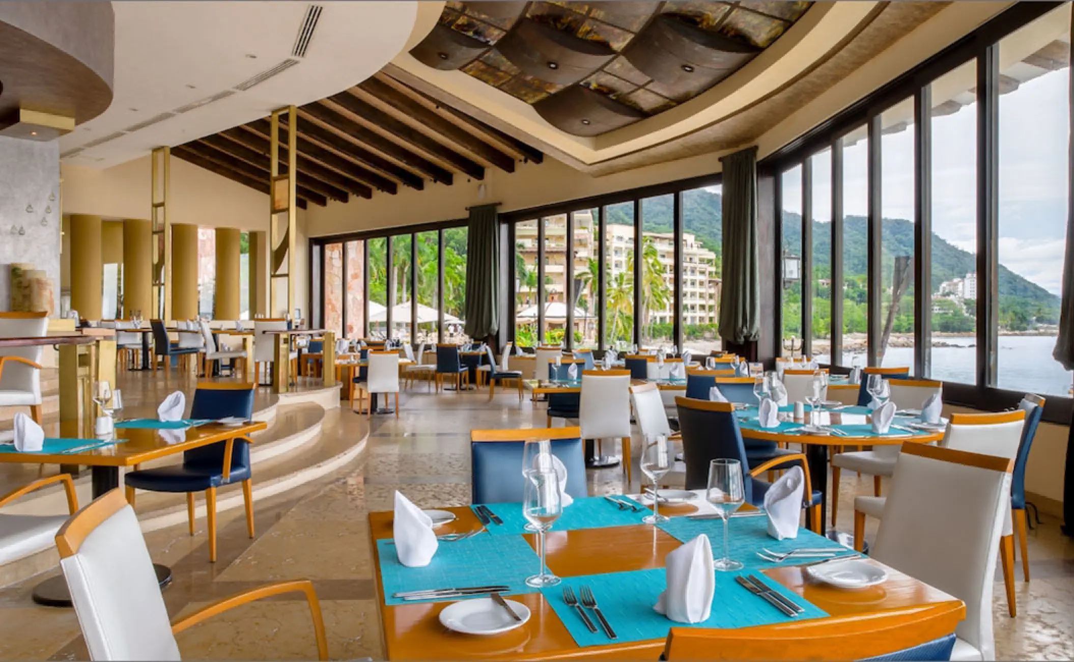 Blanca Blue restaurant interior with ocean-view floor-to-ceiling windows at Garza Blanca, Puerto Vallarta