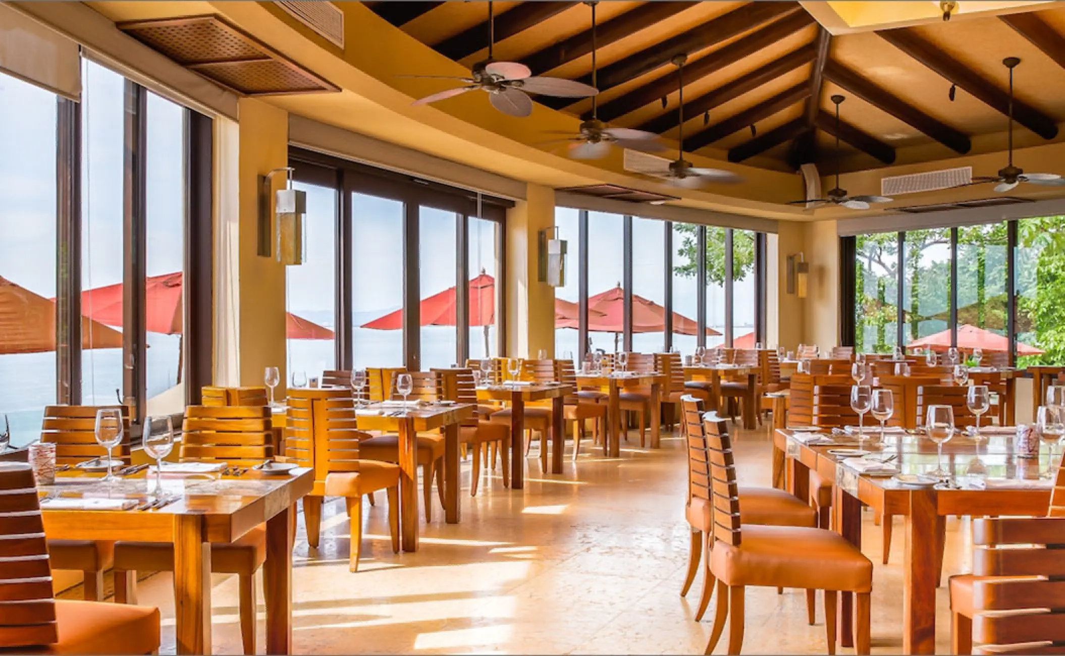 Indoor restaurant dining area with large windows at Garza Blanca Puerto Vallarta