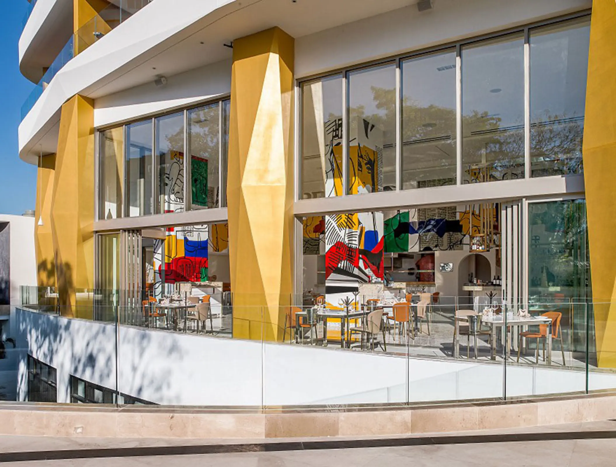 Modern outdoor dining terrace with gold columns at Hotel Mousai, Puerto Vallarta