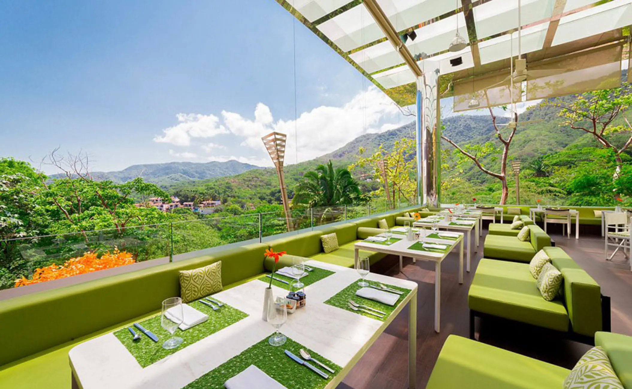 The Terrace restaurant with green lounge seating overlooking the jungle at Hotel Mousai, Puerto Vallarta