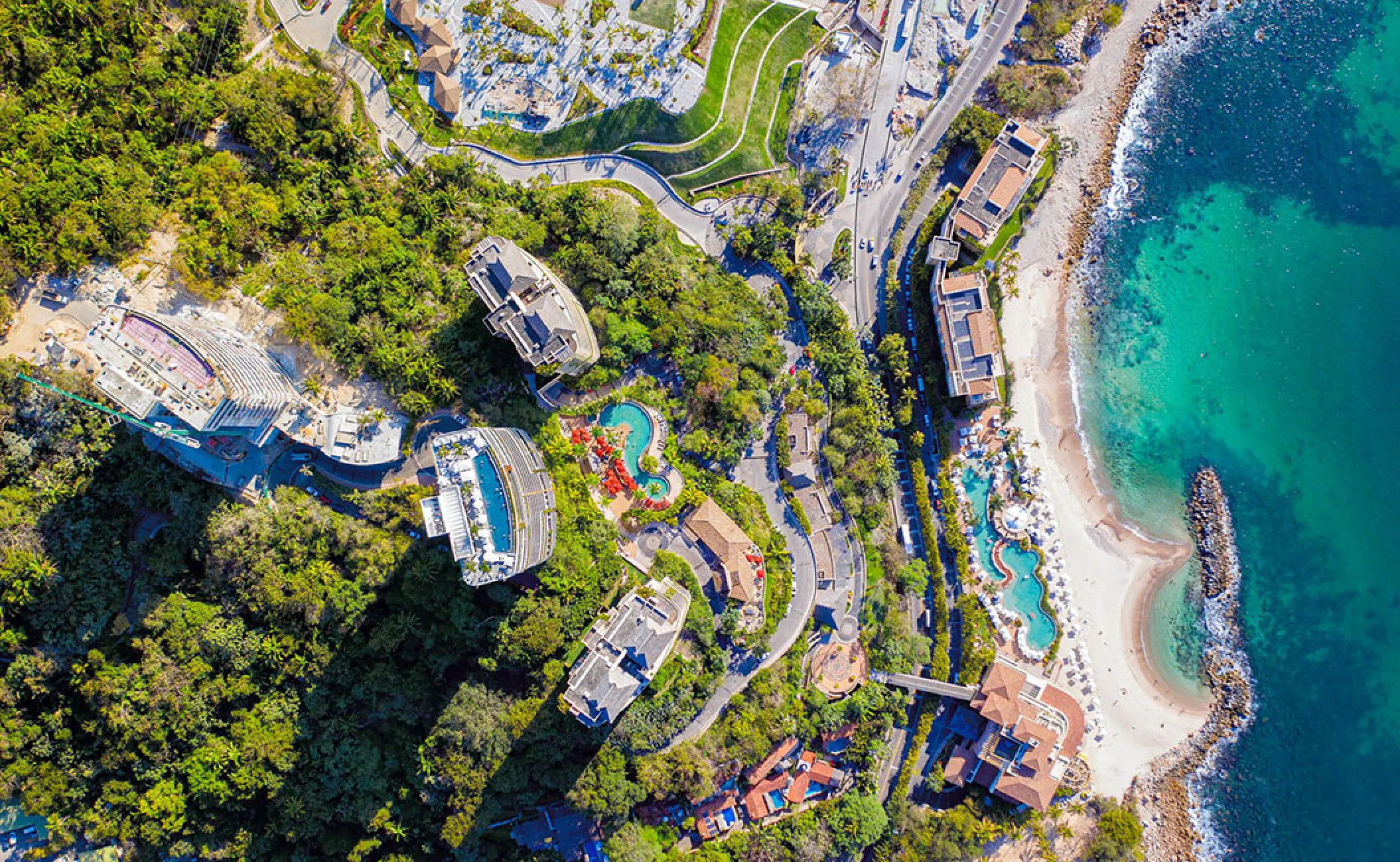 Aerial view of Hotel Mousai towers nestled in the jungle by the Pacific Ocean beach, Puerto Vallarta