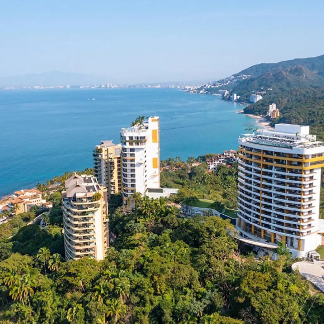 Aerial view of Hotel Mousai towers nestled in lush jungle overlooking the Pacific Ocean, Puerto Vallarta