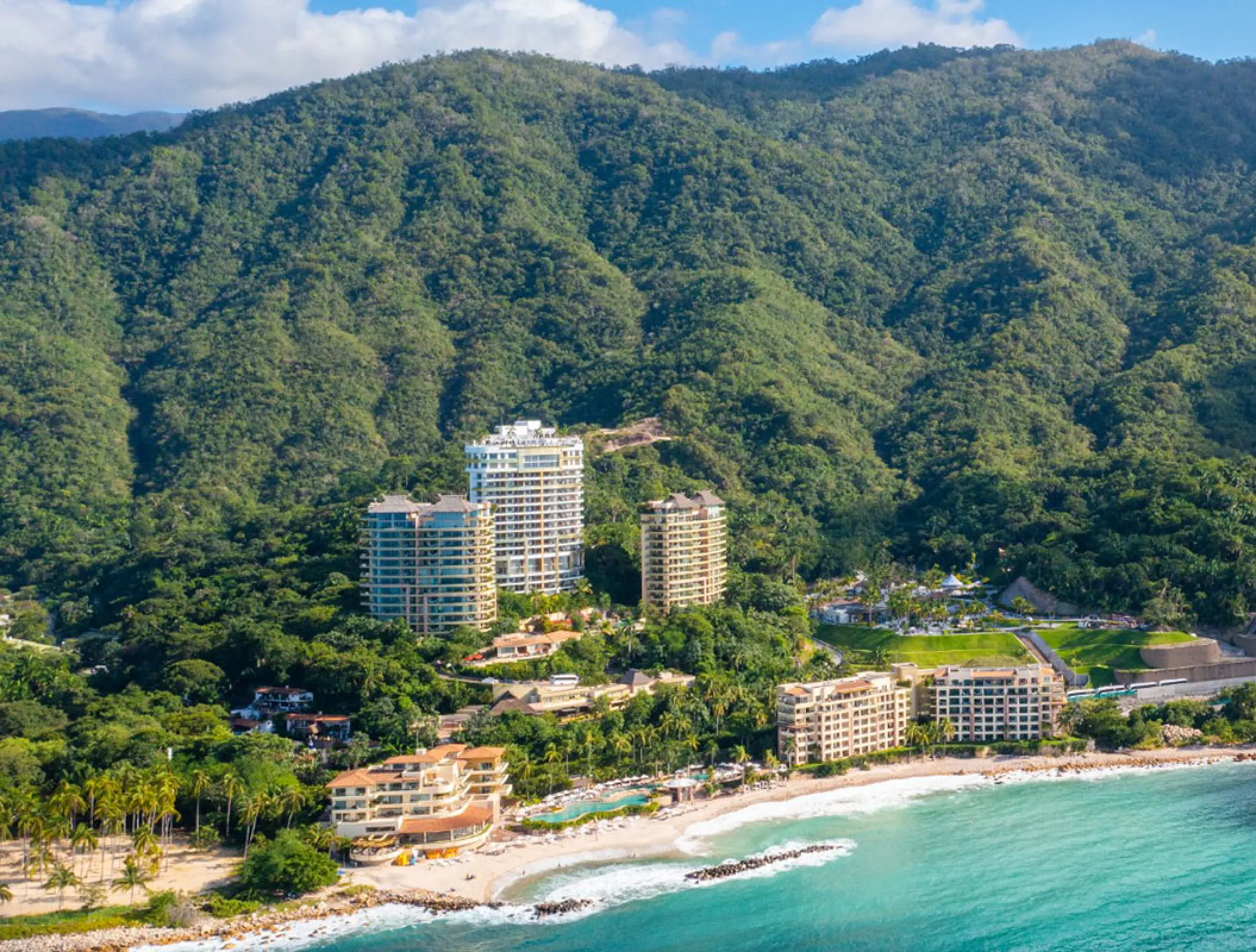 Aerial view of Hotel Mousai towers nestled in the jungle mountainside by the beach, Puerto Vallarta