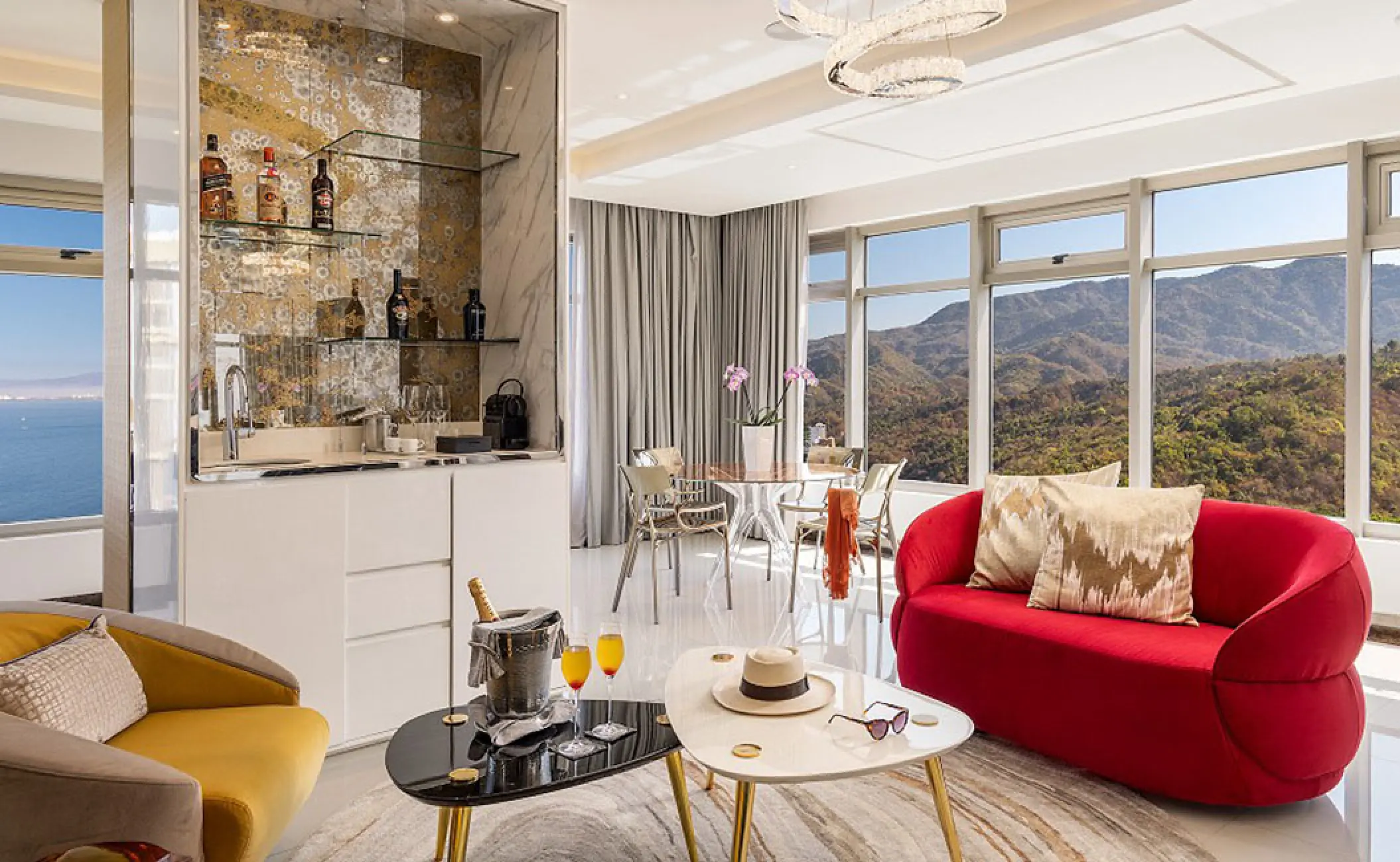 Hotel Mousai master suite living area with red sofa and mountain views, Puerto Vallarta