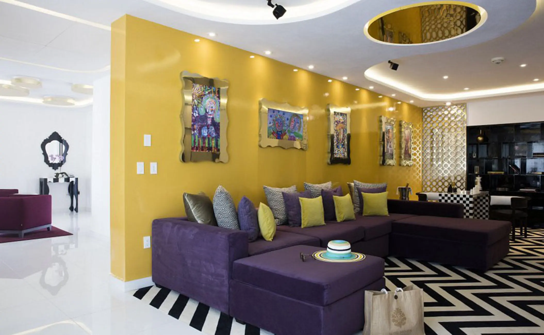 Modern penthouse living area with purple sofa and yellow accent wall at Hotel Mousai, Puerto Vallarta