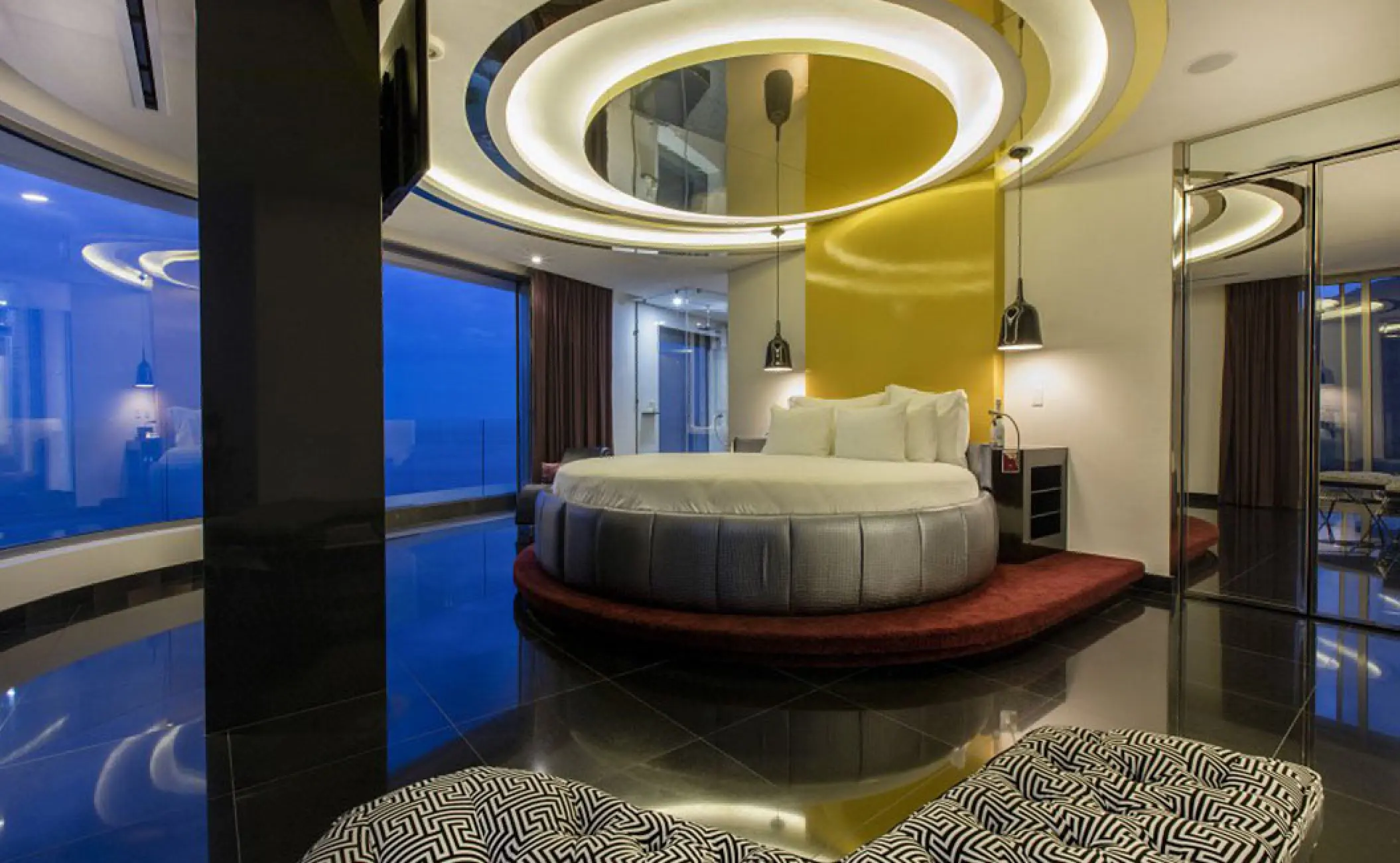 The Penthouse suite with a circular bed and floor-to-ceiling windows at Hotel Mousai, Puerto Vallarta