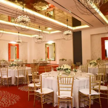 Red Room ballroom wedding reception with gold chairs and crystal chandeliers at Hotel Mousai, Puerto Vallarta