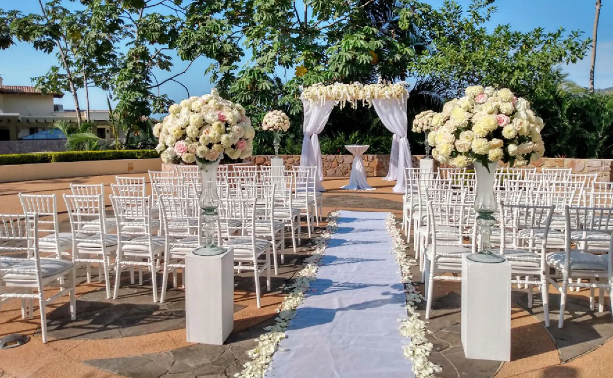 Wedding ceremony setup with white chairs and floral arch at Garza Blanca Preserve, Puerto Vallarta