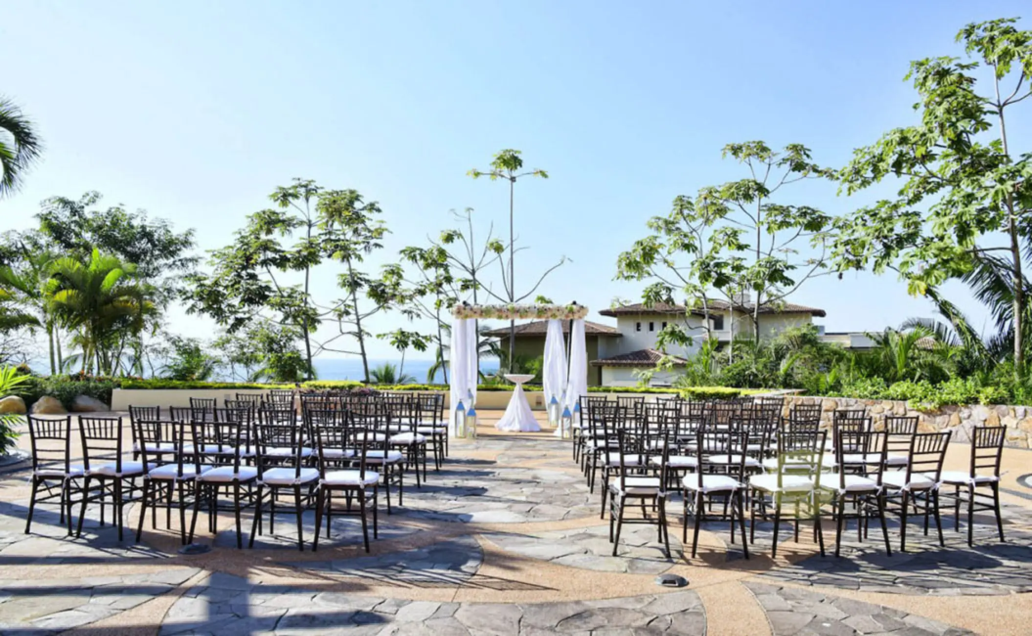 Outdoor terrace wedding ceremony setup with white draped arch at Garza Blanca, Puerto Vallarta