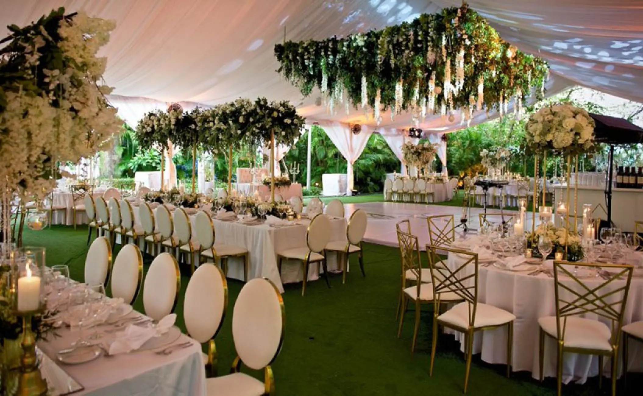 Elegant outdoor wedding reception with floral centerpieces and hanging greenery at Garza Blanca, Puerto Vallarta
