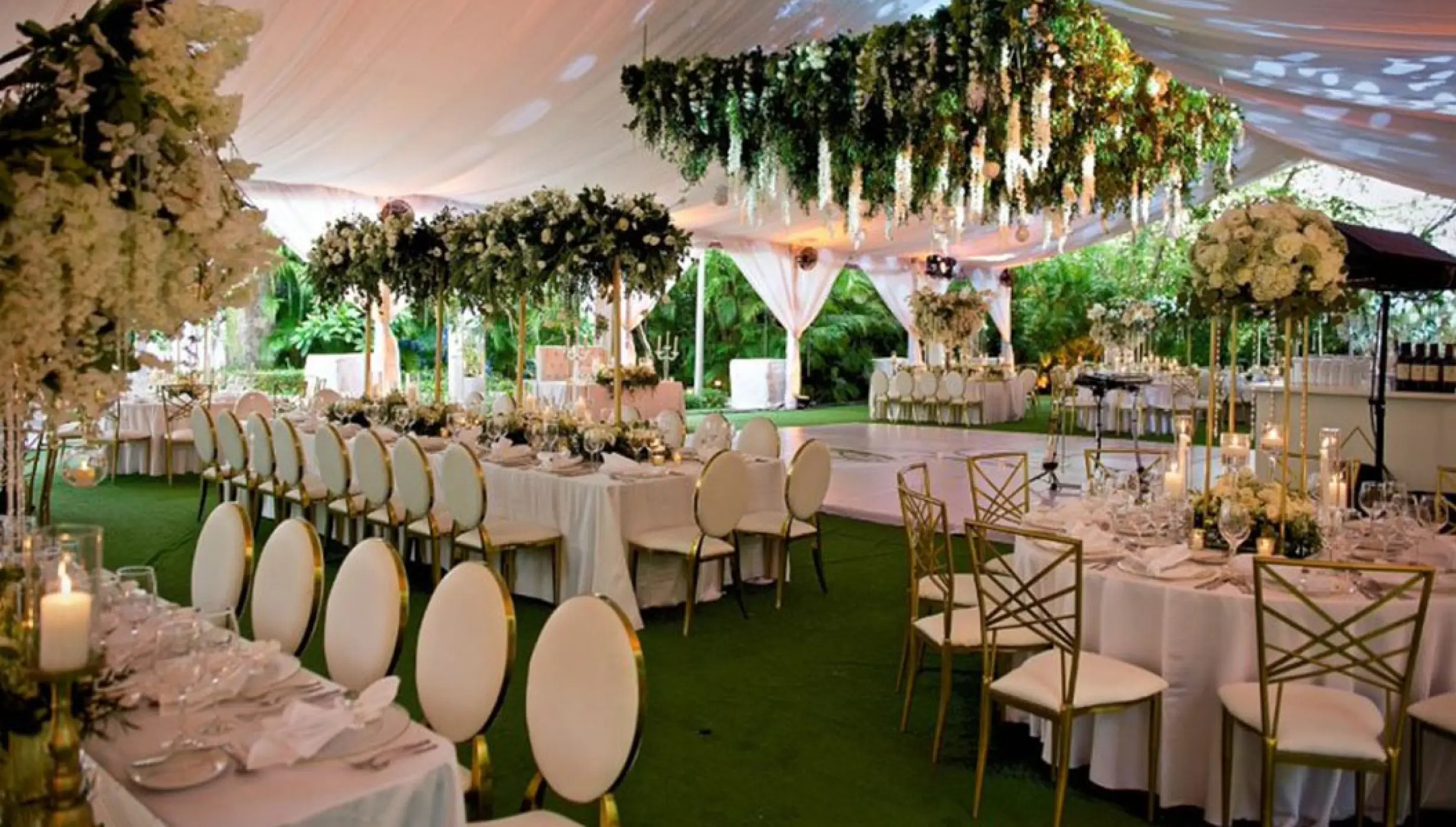 Tent wedding reception with floral centerpieces and hanging greenery at Garza Blanca Puerto Vallarta