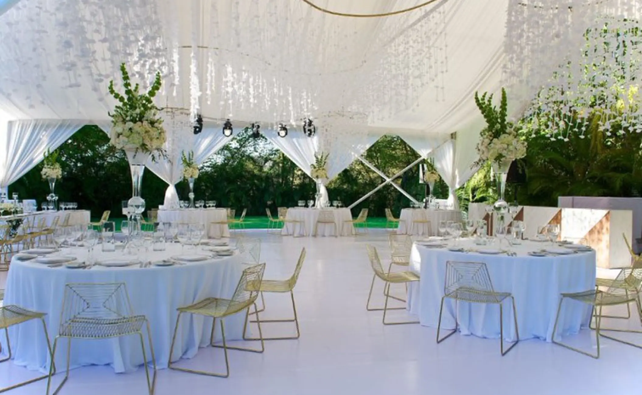 White wedding reception with floral centerpieces and gold chairs at Hotel Mousai, Puerto Vallarta