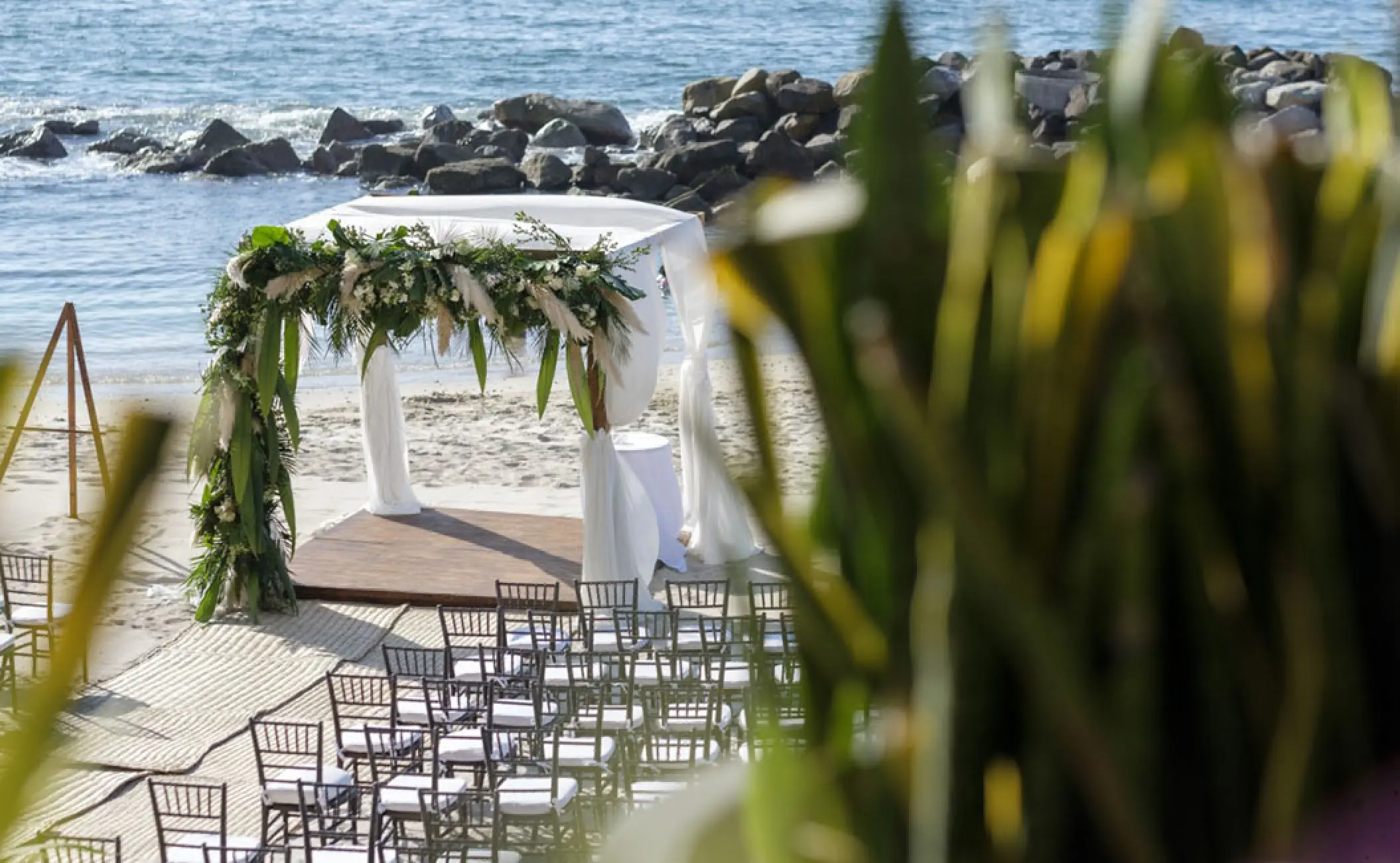 Beachfront wedding ceremony setup at Hotel Mousai, Puerto Vallarta