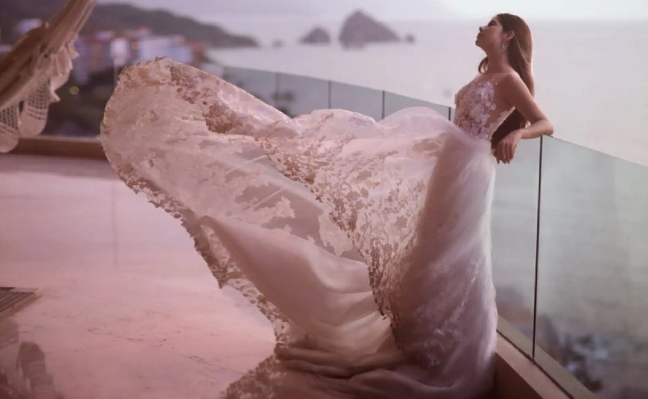 Bride in a lace dress posing on a balcony overlooking the ocean at Garza Blanca Preserve, Puerto Vallarta