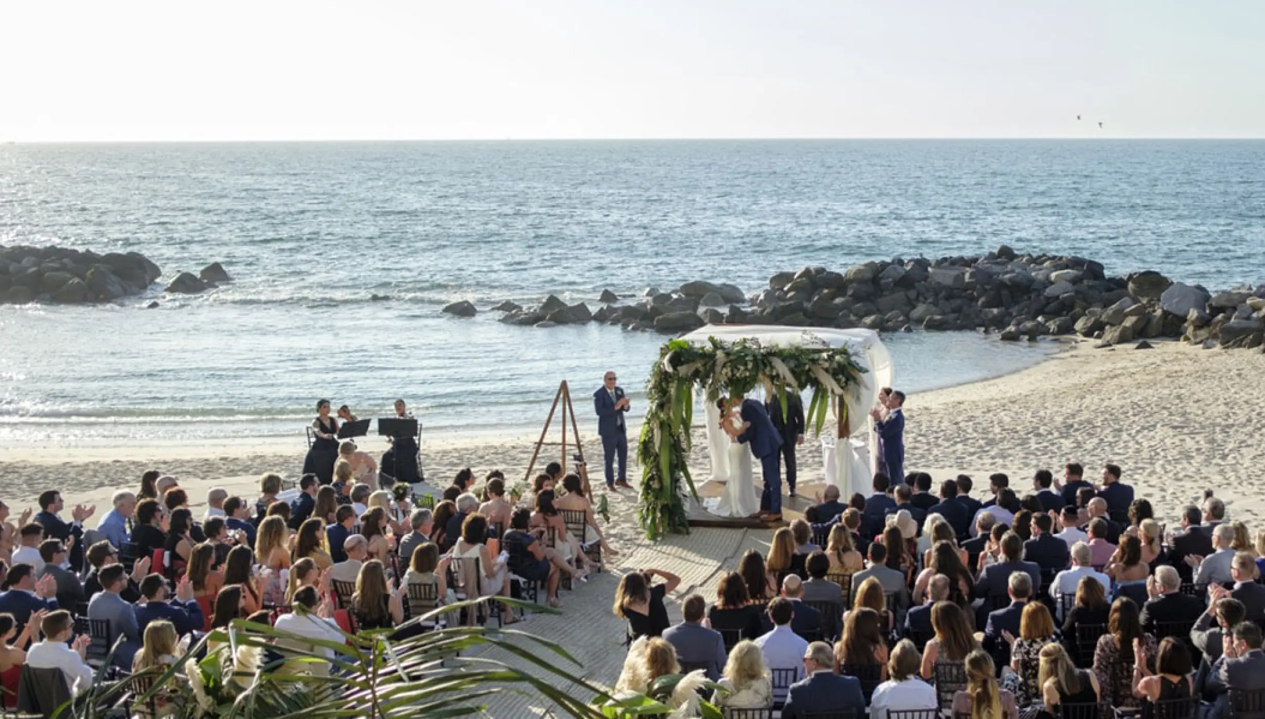 Beachfront wedding ceremony with guests seated on the sand at Garza Blanca, Puerto Vallarta