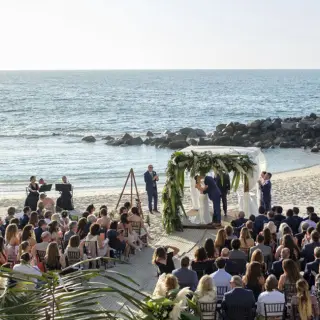 Beachfront wedding ceremony under a floral arch at Garza Blanca Puerto Vallarta