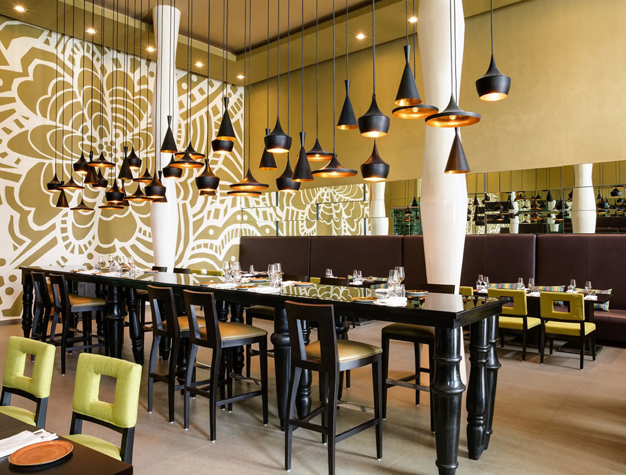 Latino restaurant interior with black pendant lights and floral wall art at Margaritaville Island Reserve Riviera Cancun