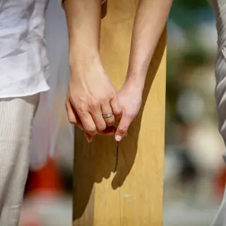 Close-up of a bride and groom holding hands during a wedding ceremony at Riu Palace Aquarelle, Montego Bay